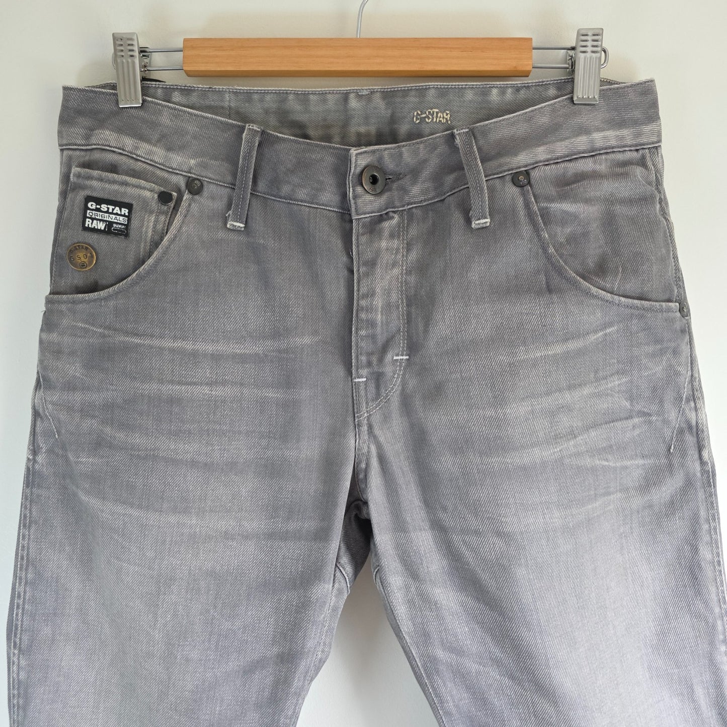 G-Star grey straight jeans with biker style detailing and subtle wear at the hem.
