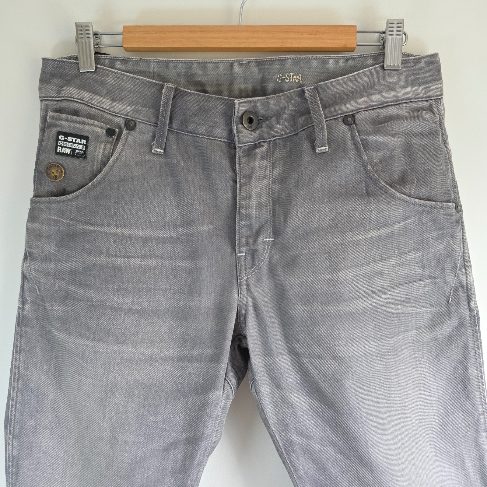 G-Star grey straight jeans with biker style detailing and subtle wear at the hem.