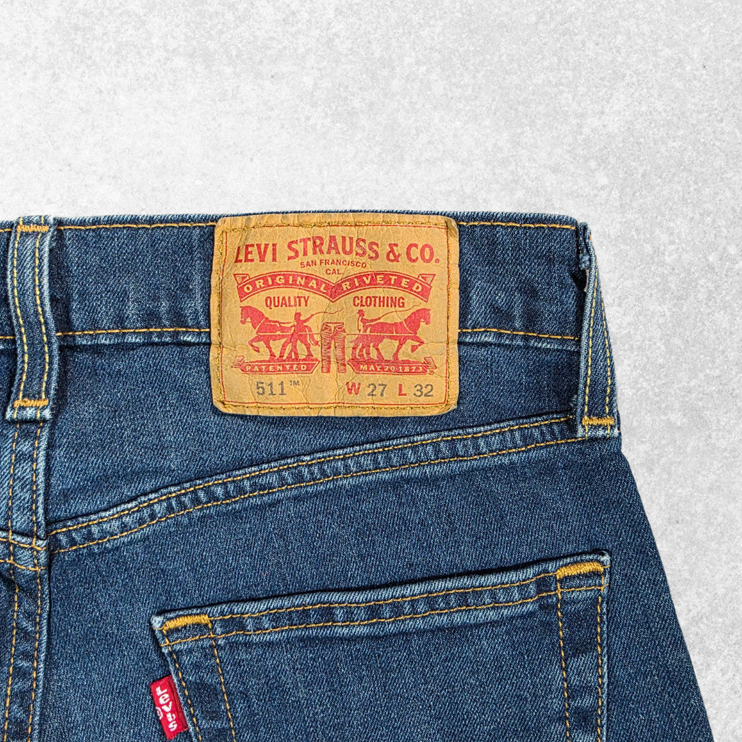 Levi's blue straight jeans with distressed patches and natural wear, made in USA.
