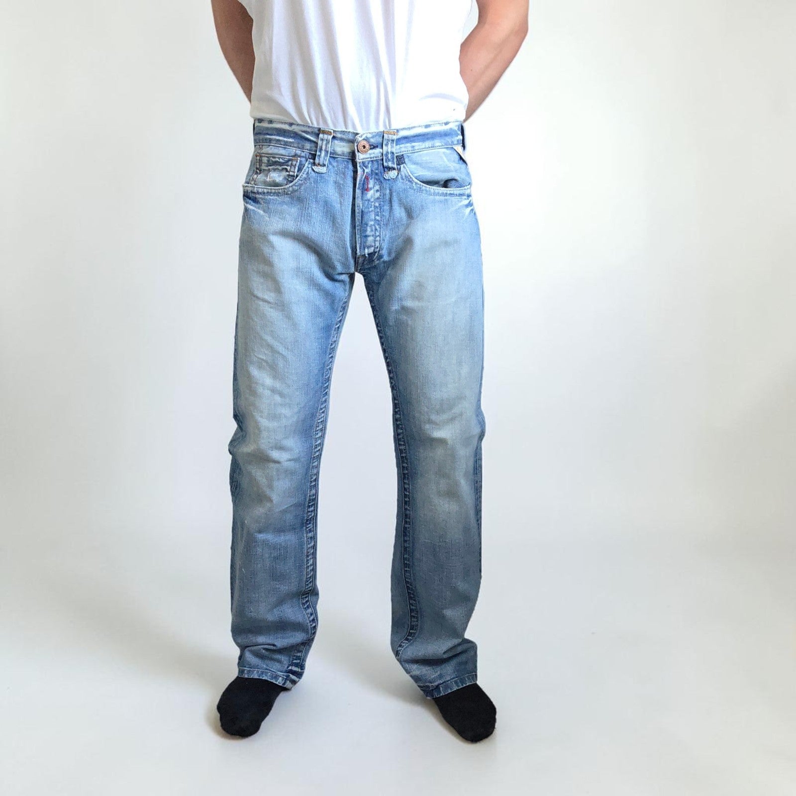 Replay blue straight jeans with button fly and light distressed pocket detailing.