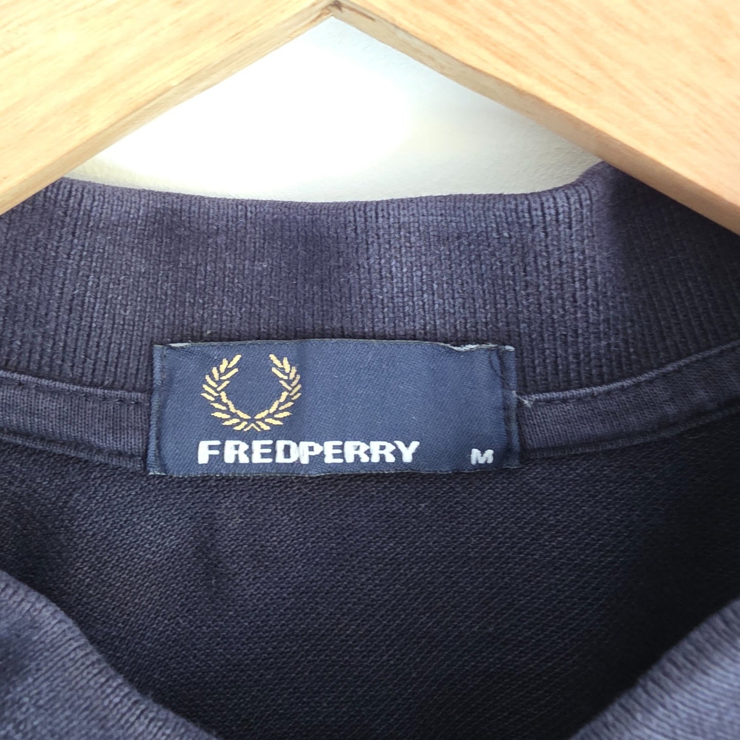 Fred Perry navy blue polo shirt with twin tipped collar and cotton material.