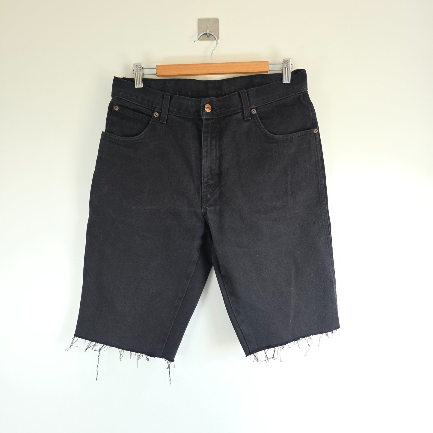 Wrangler black denim shorts W33 with frayed hems and copper-toned button.