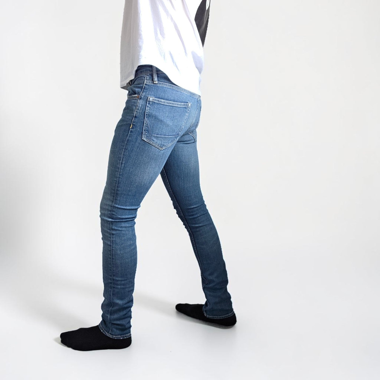 AllSaints blue skinny jeans with faded wash and modern slim fit design.