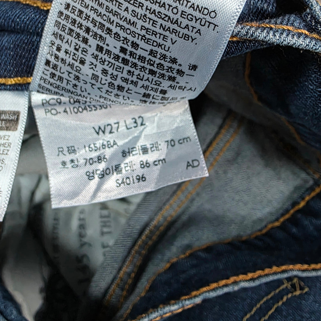 Levi's blue straight jeans with distressed patches and natural wear, made in USA.