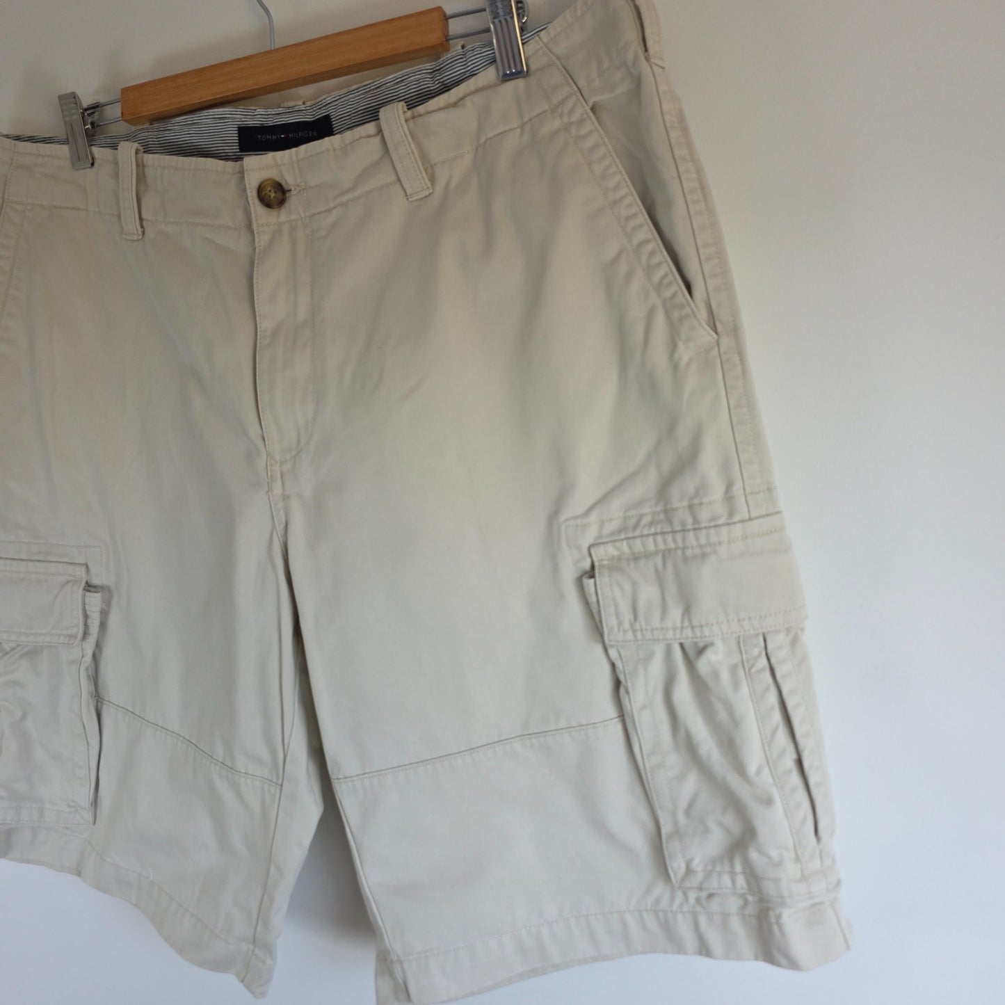 Tommy Hilfiger beige cargo shorts with utility pockets and cotton material.