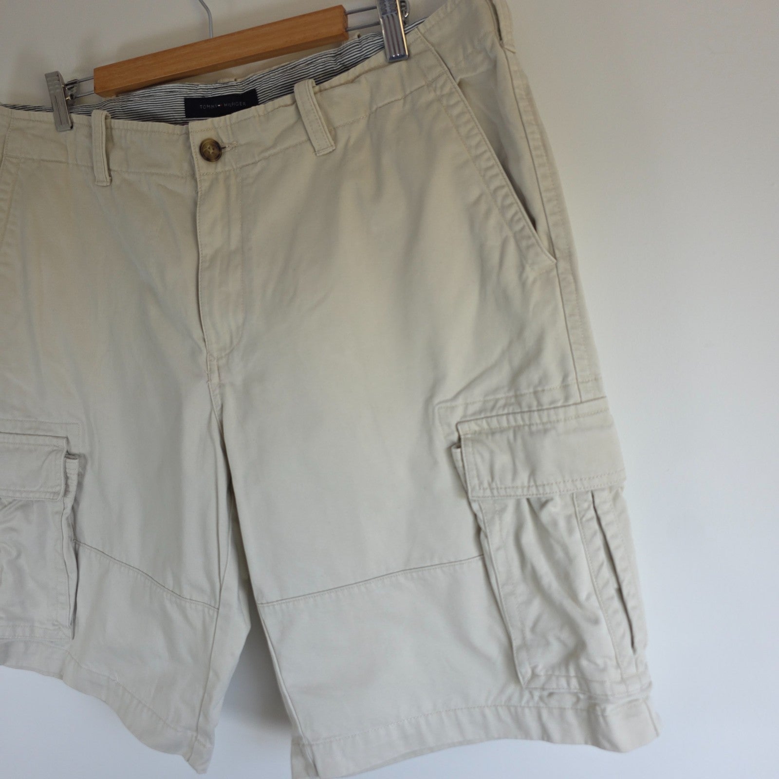 Tommy Hilfiger beige cargo shorts with utility pockets and cotton material.