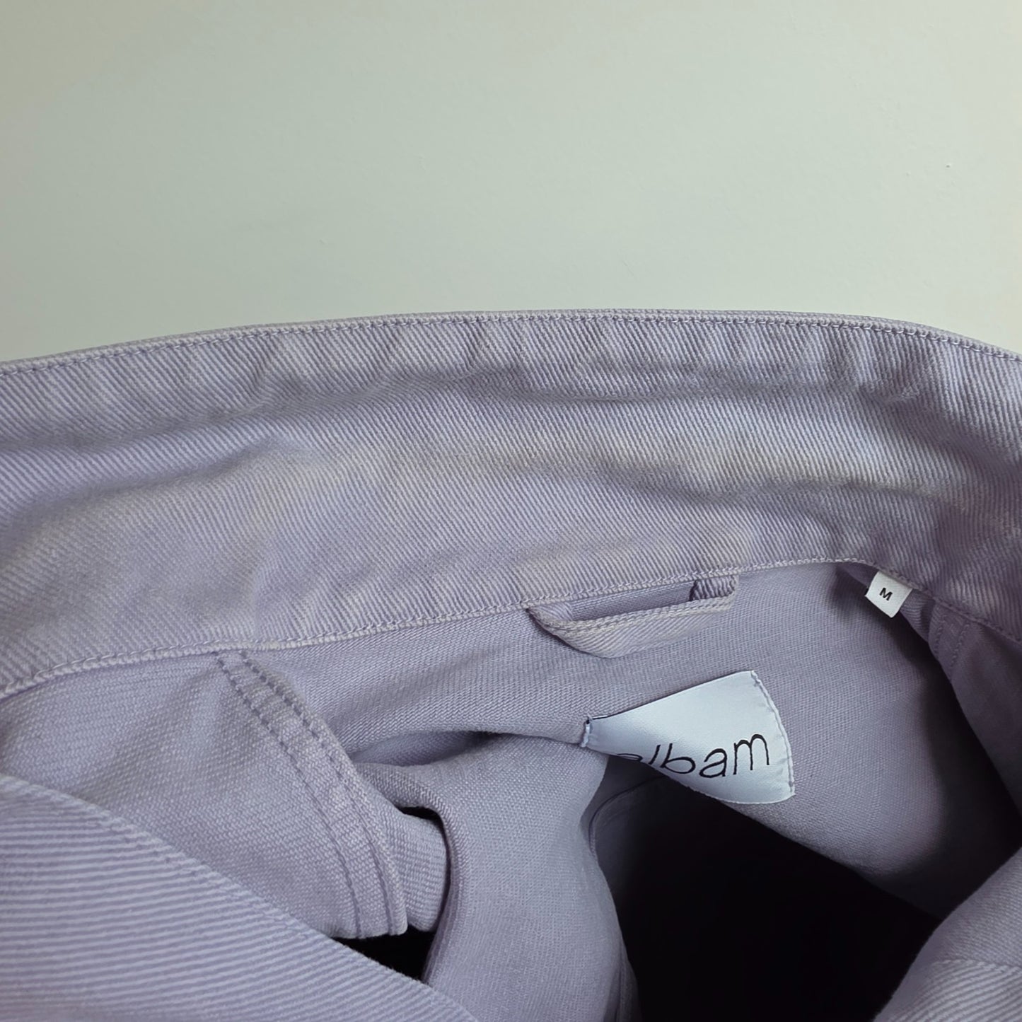Albam lilac denim jacket with button front, chest pockets, and side pockets.