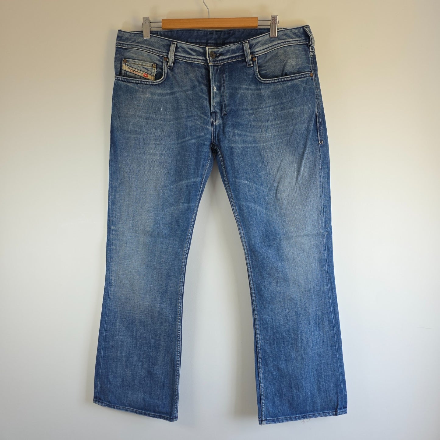 Diesel blue bootcut jeans with button fly and vintage Zathan fit, 100% cotton.