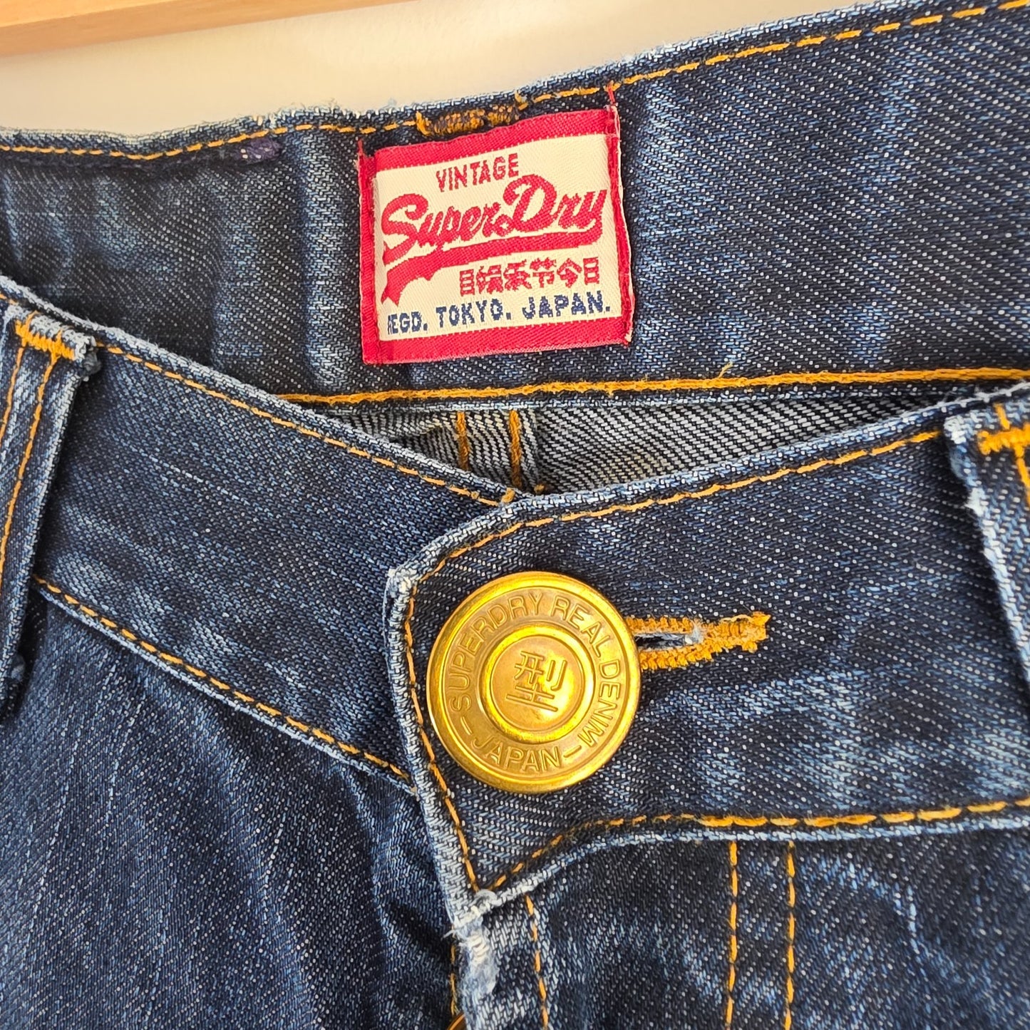 Superdry blue straight jeans with button fly, vintage raw denim, light wear.
