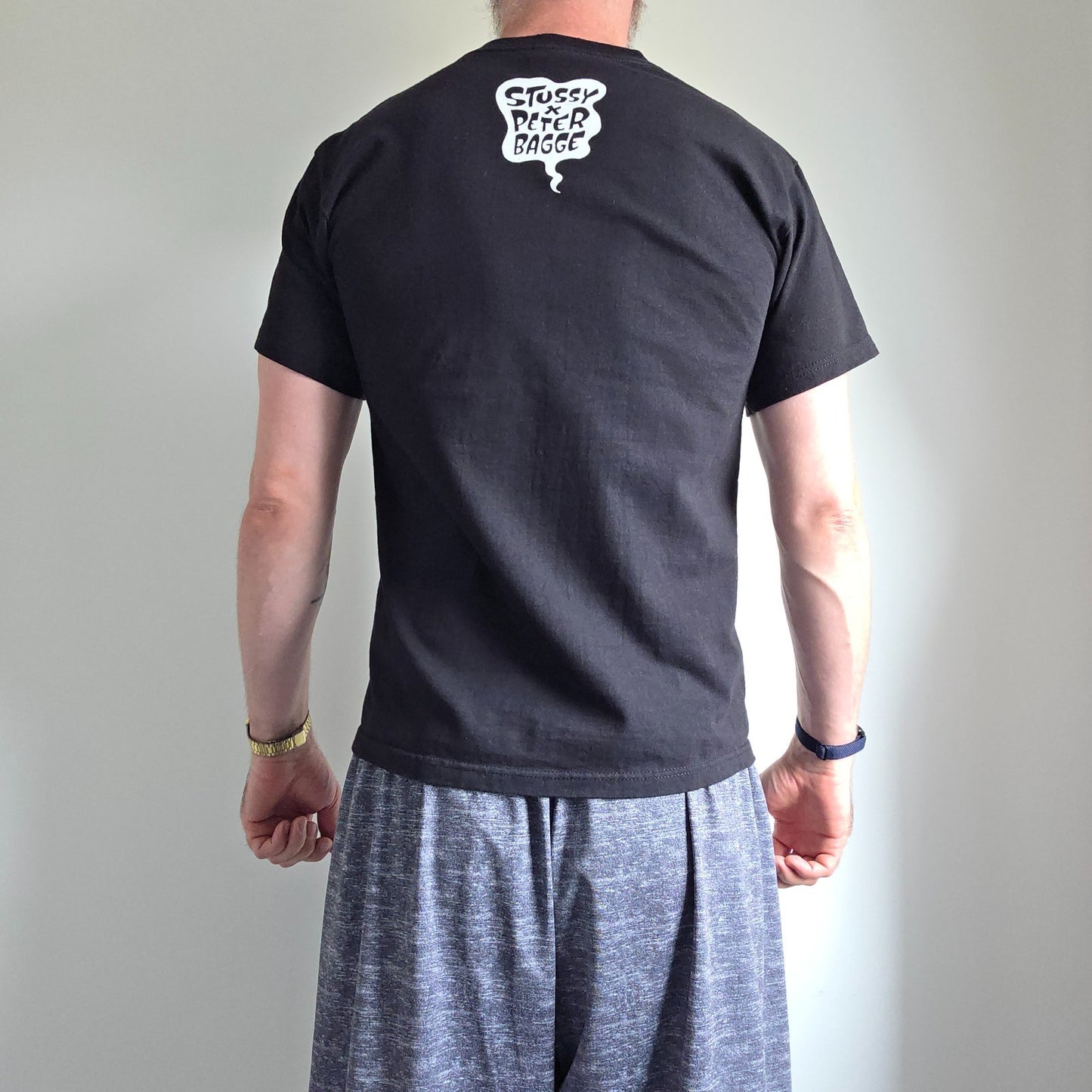 Stüssy black comic graphic t-shirt featuring large "Shout! Smash!" print, cotton material.