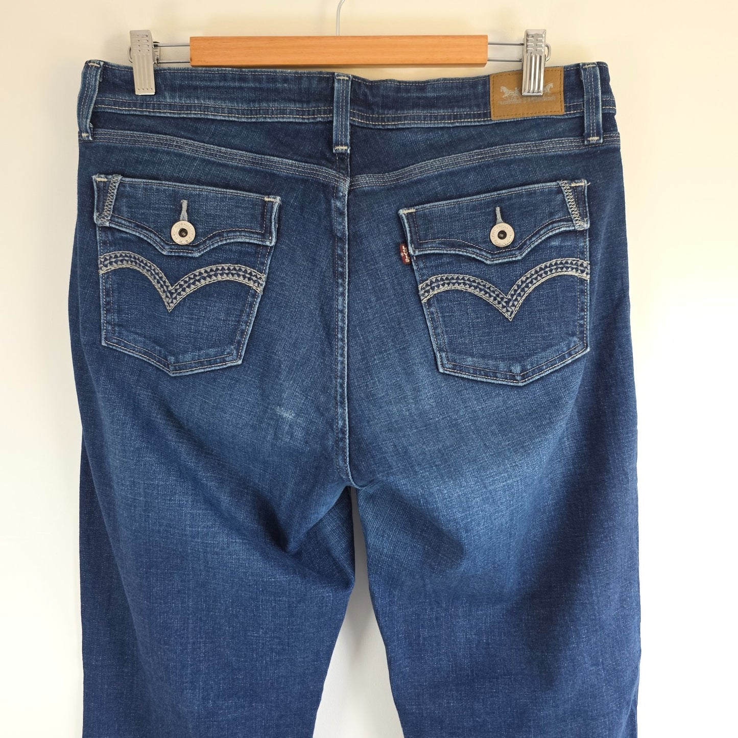 Levi's blue straight jeans with distressed details and classic 501 logo.