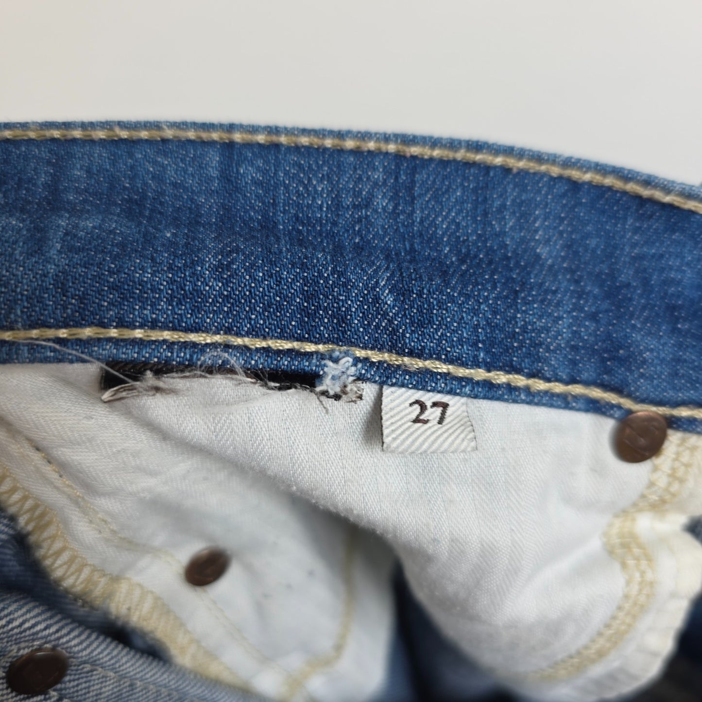 7 For All Mankind blue straight jeans with low rise and subtle branding details.