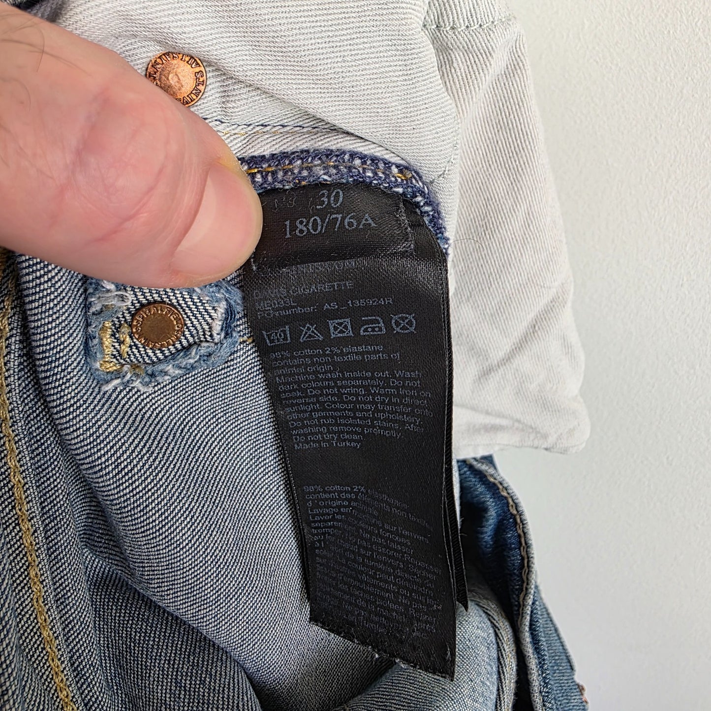 AllSaints blue skinny jeans with faded wash and modern slim fit design.
