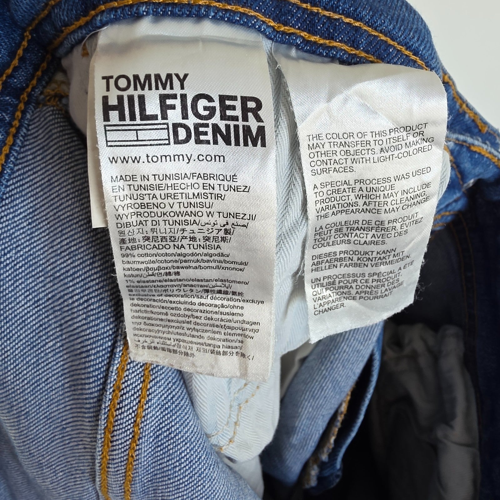 Tommy Hilfiger blue tapered jeans with stretch denim and small rip detail.