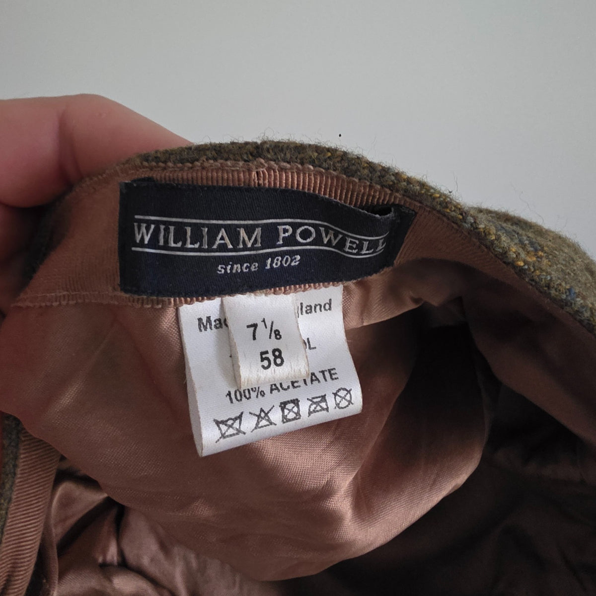 William Powell brown tweed flat cap with stitched panel construction and subtle flecks.