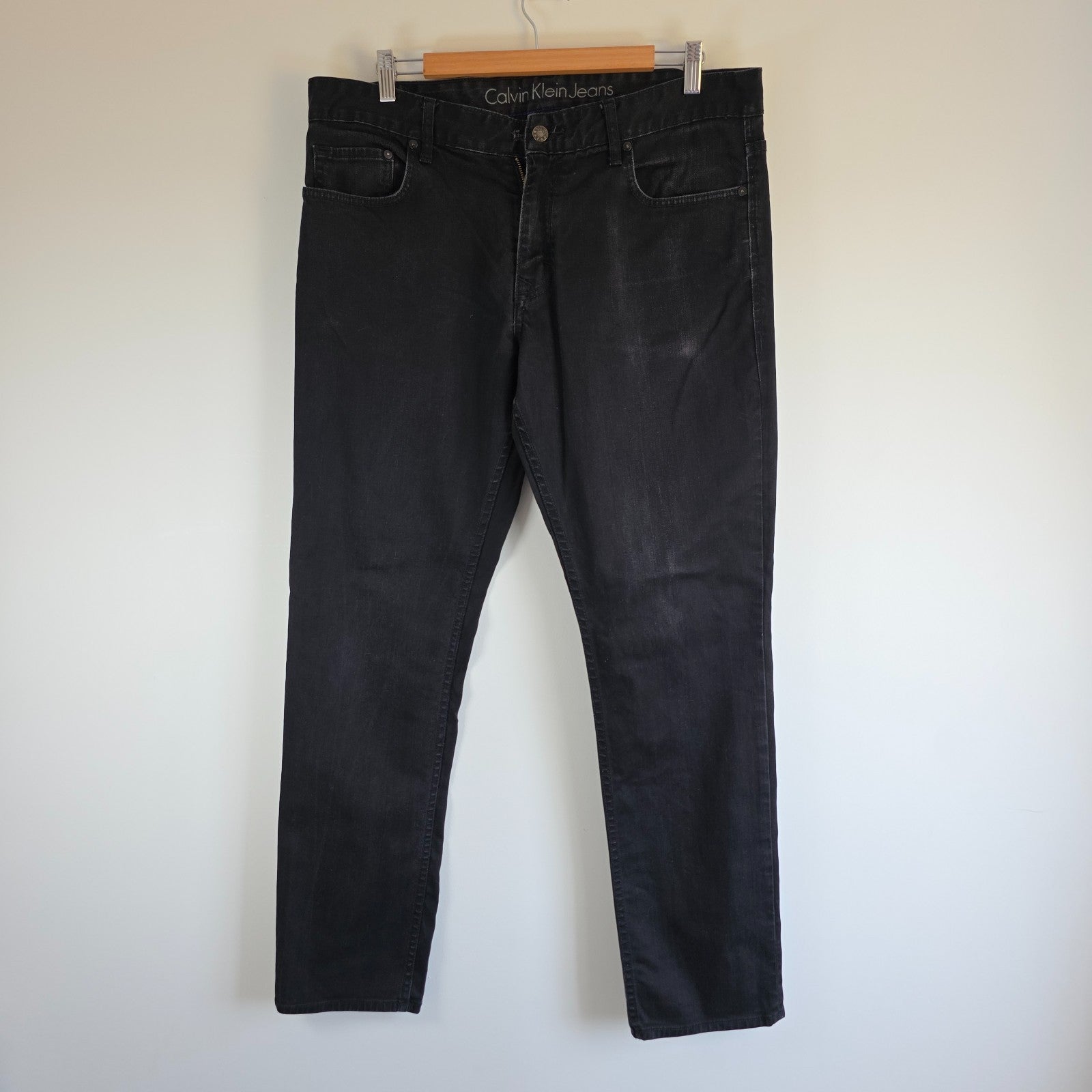 Calvin Klein black straight jeans with logo patch, stretch cotton blend, slim fit design.