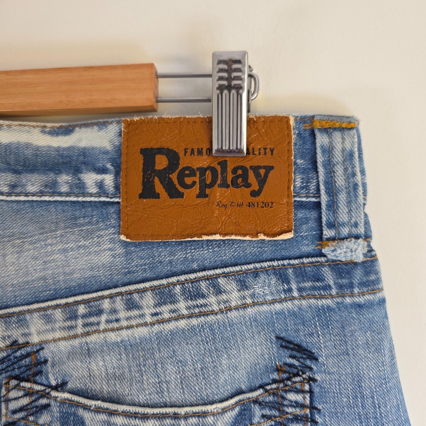 Replay blue straight jeans with button fly and light distressed pocket detailing.
