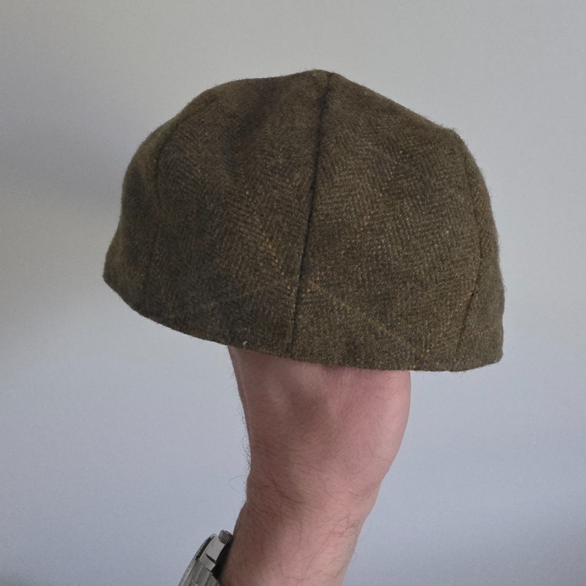 William Powell brown tweed flat cap with stitched panel construction and subtle flecks.