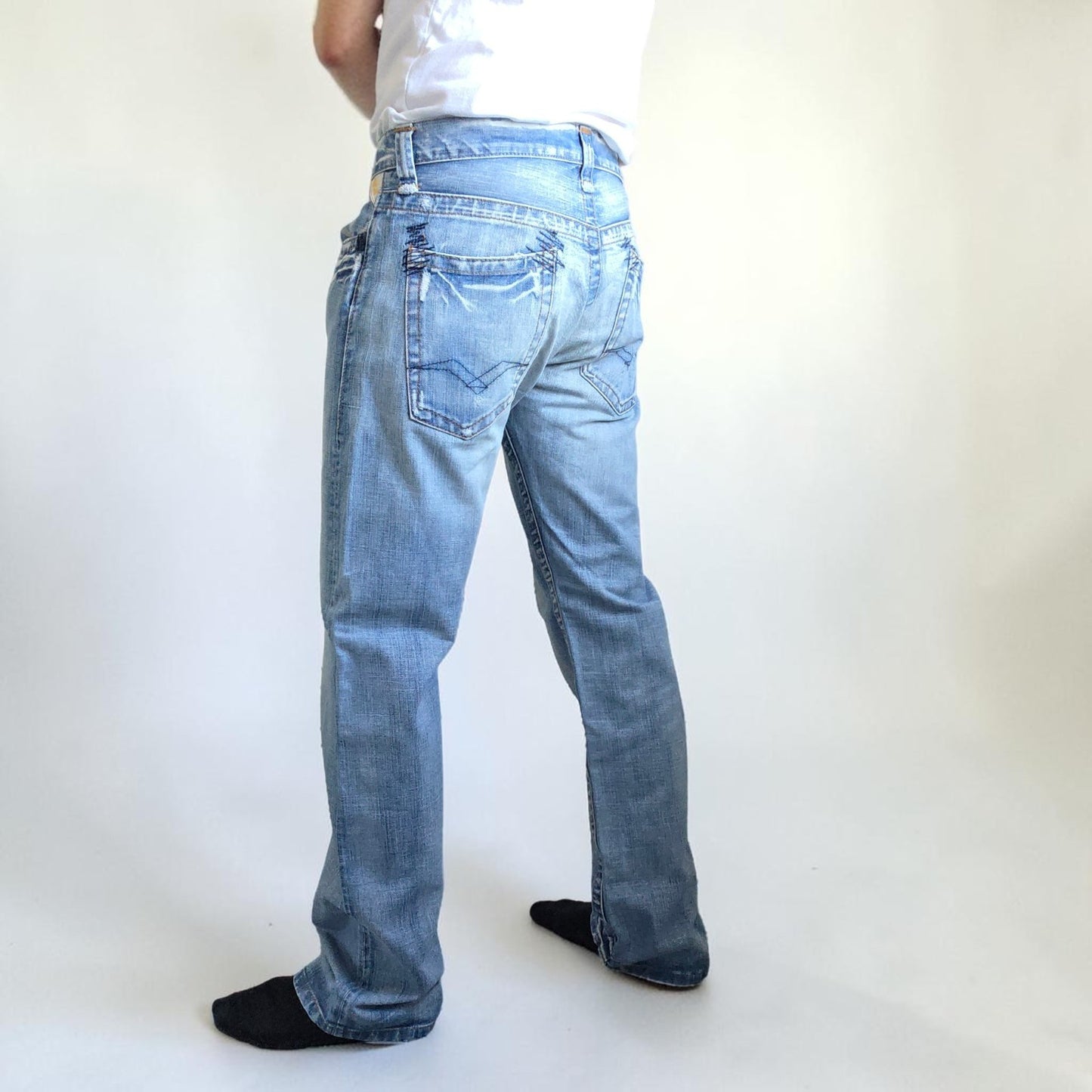 Replay blue straight jeans with button fly and light distressed pocket detailing.