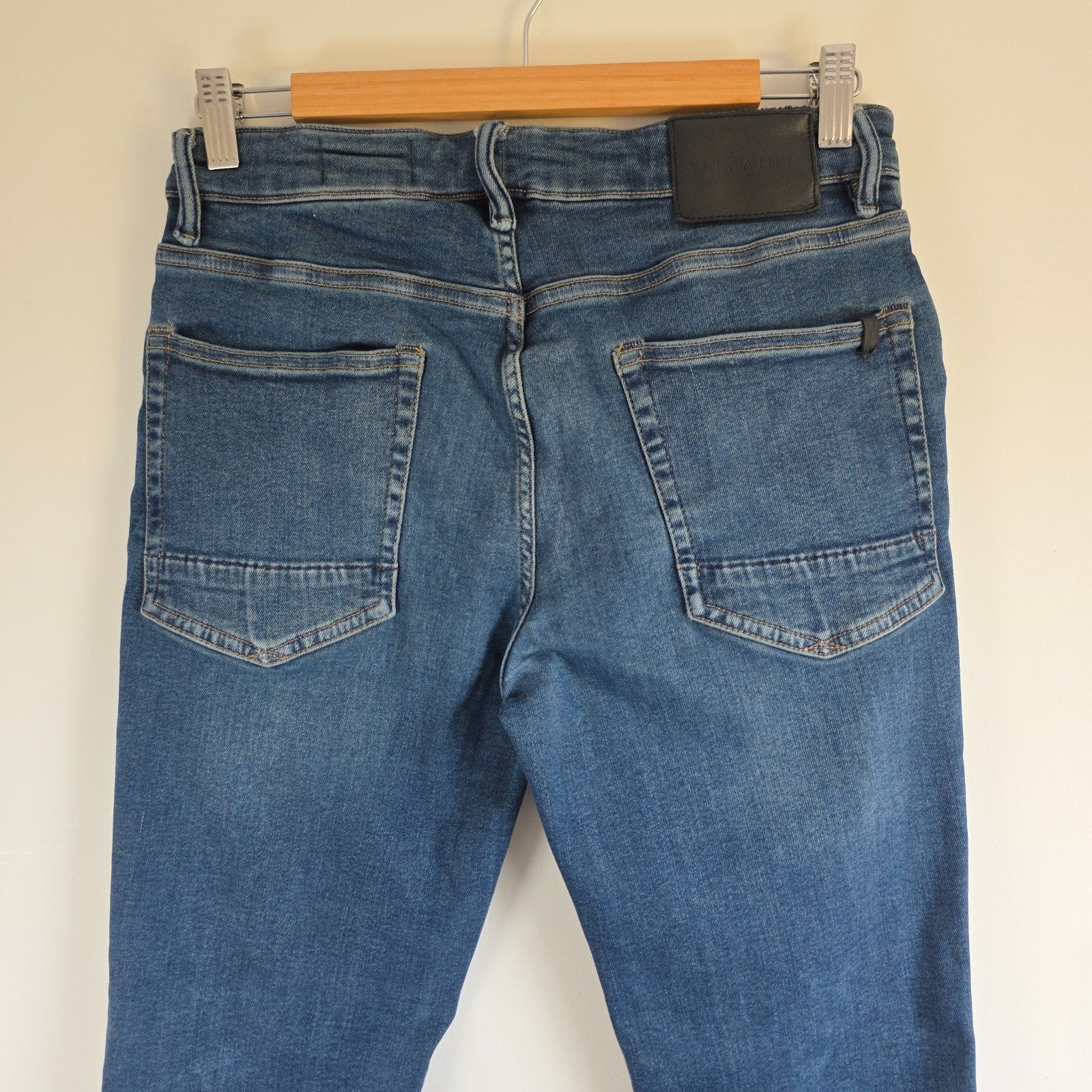 AllSaints blue straight jeans with button fly and stretch cotton-elastane blend.
