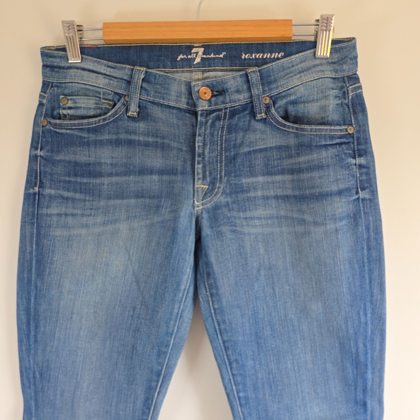 7 For All Mankind blue straight jeans with low rise and subtle branding details.