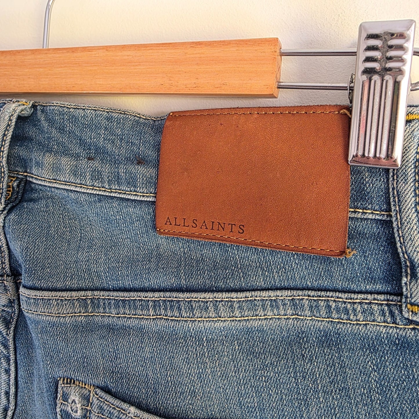 AllSaints blue skinny jeans with faded wash and modern slim fit design.