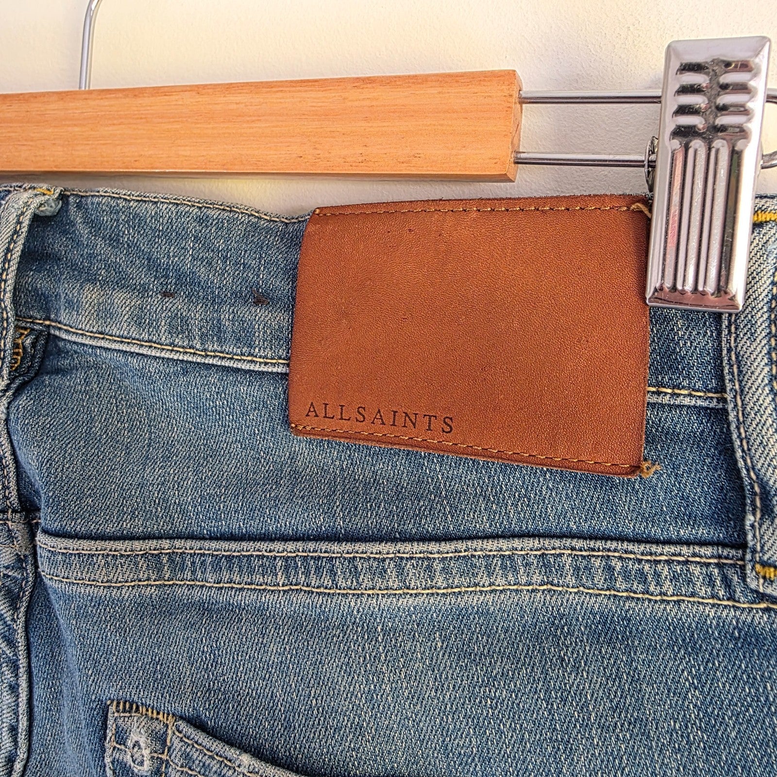 AllSaints blue skinny jeans with faded wash and modern slim fit design.
