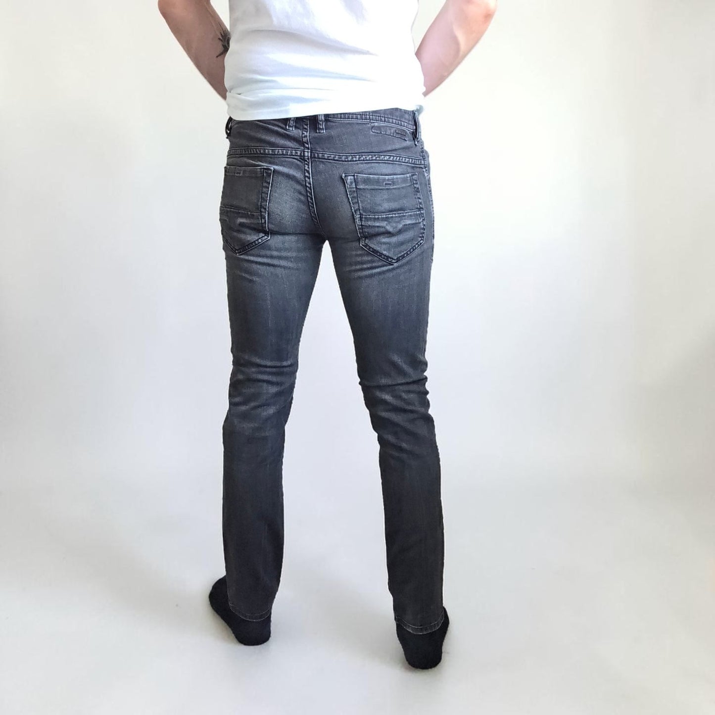 Diesel black straight jeans with grey wash, stretch denim, and branded tag.