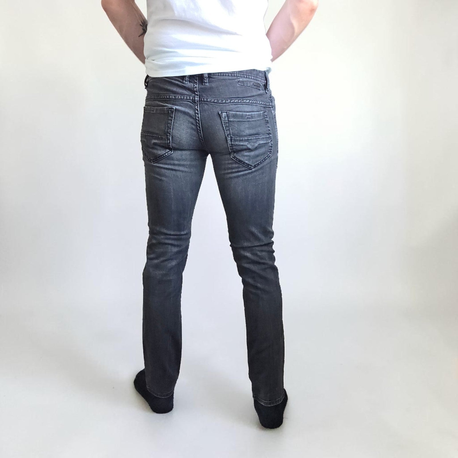 Diesel black straight jeans with grey wash, stretch denim, and branded tag.