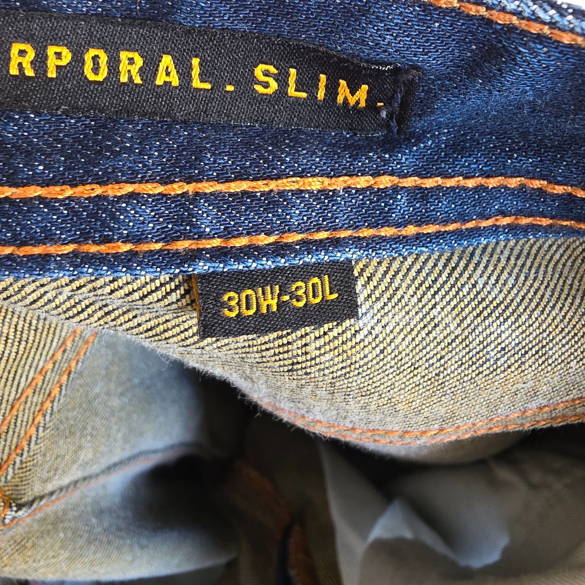 Superdry blue slim jeans with subtle fading, contrast orange stitching, and five-pocket design.