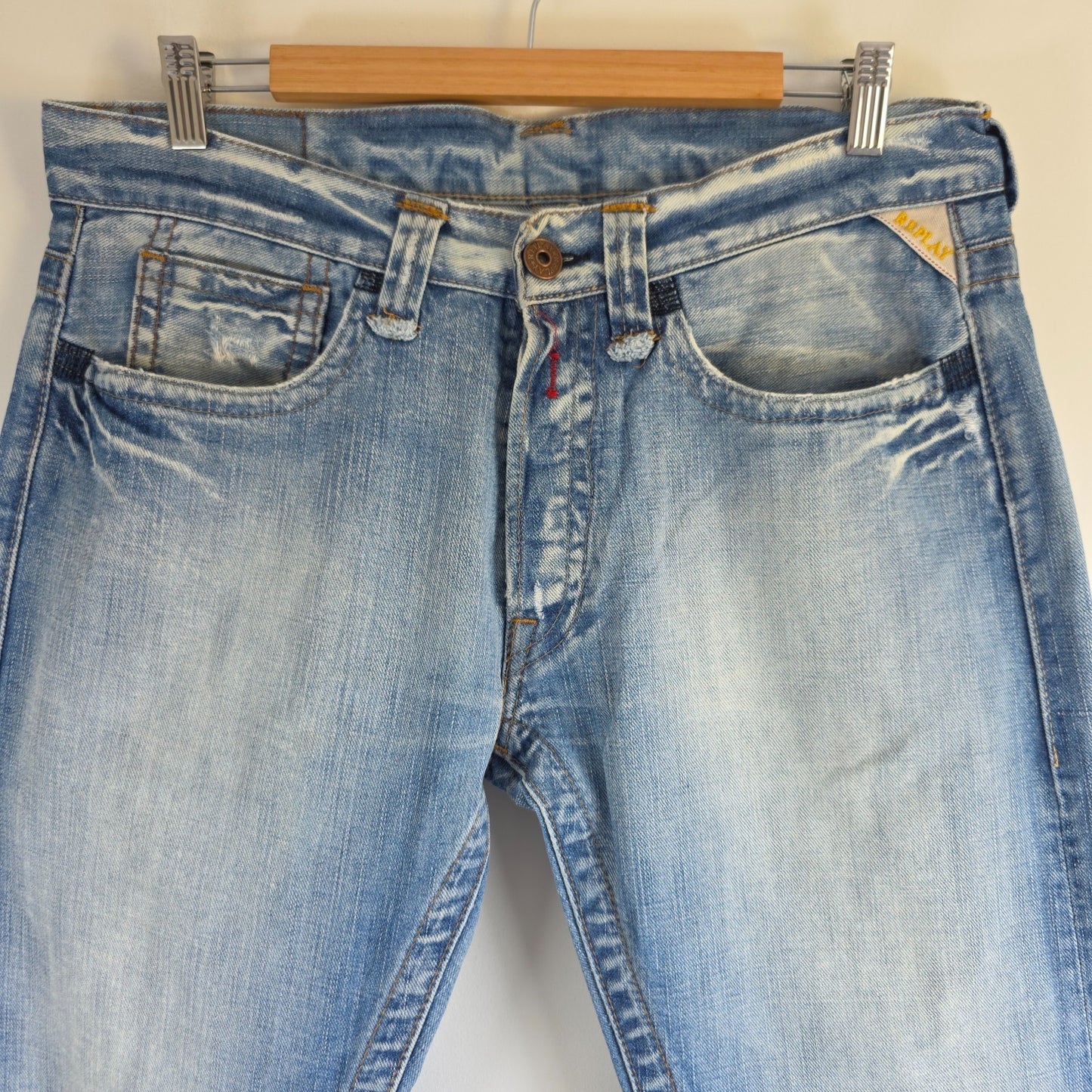 Replay blue straight jeans with button fly and light distressed pocket detailing.