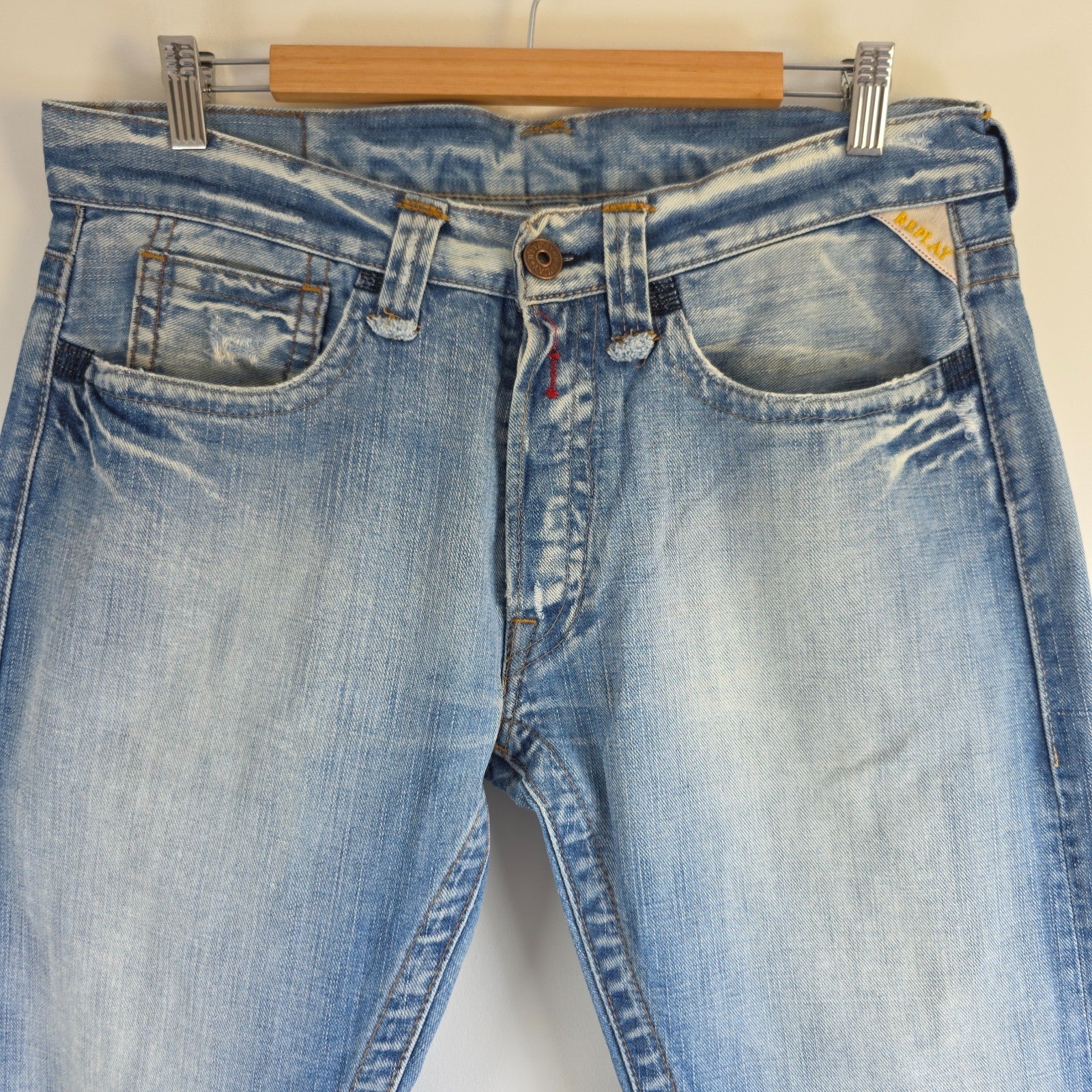 Replay blue straight jeans with button fly and light distressed pocket detailing.