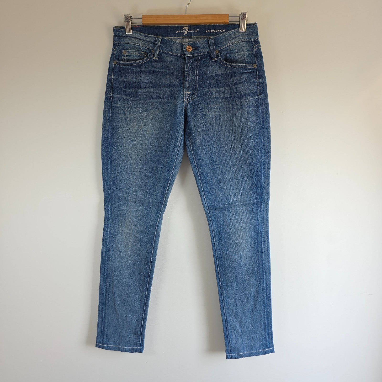7 For All Mankind blue straight jeans with low rise and subtle branding details.