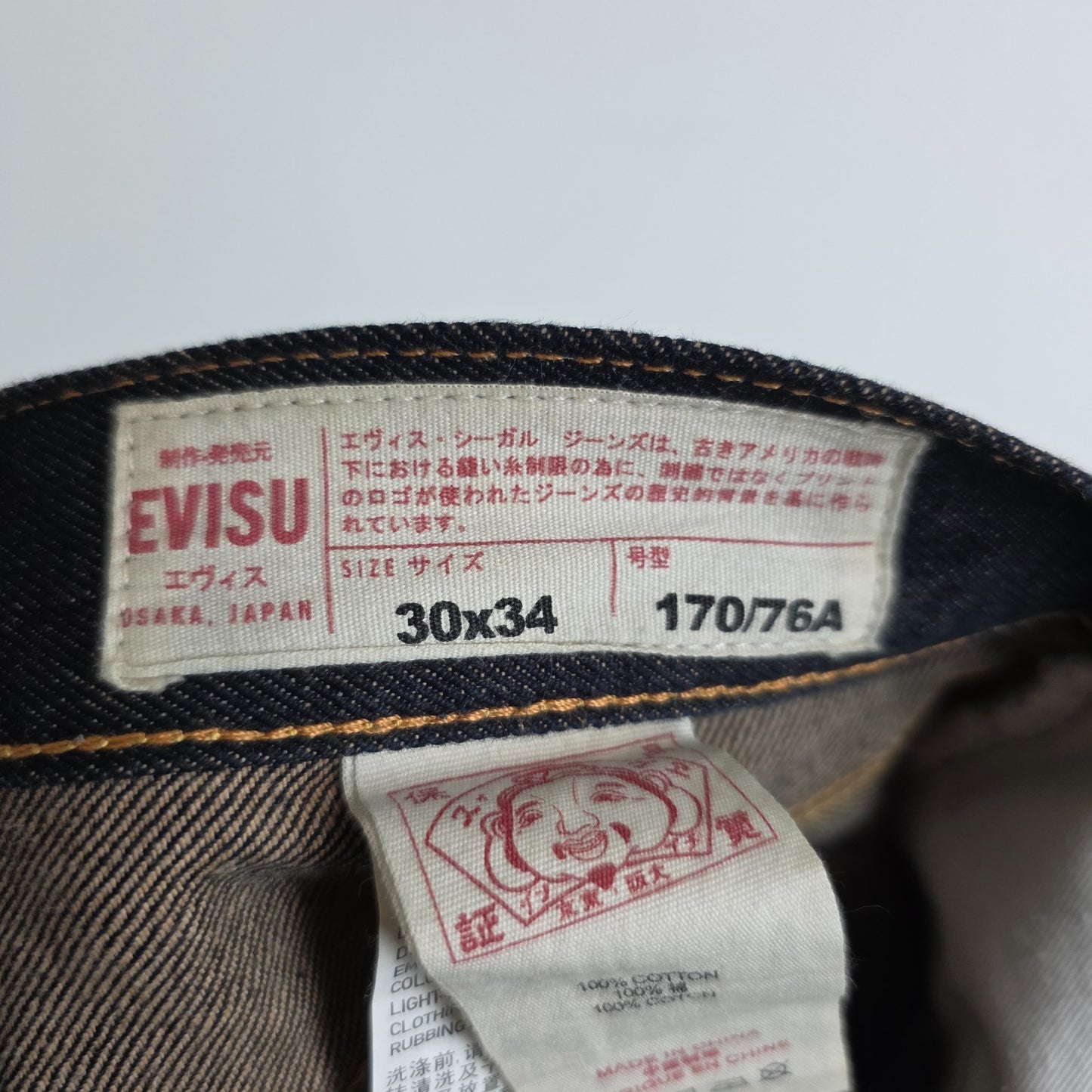 Evisu blue straight jeans with selvedge denim and button fly detailing.
