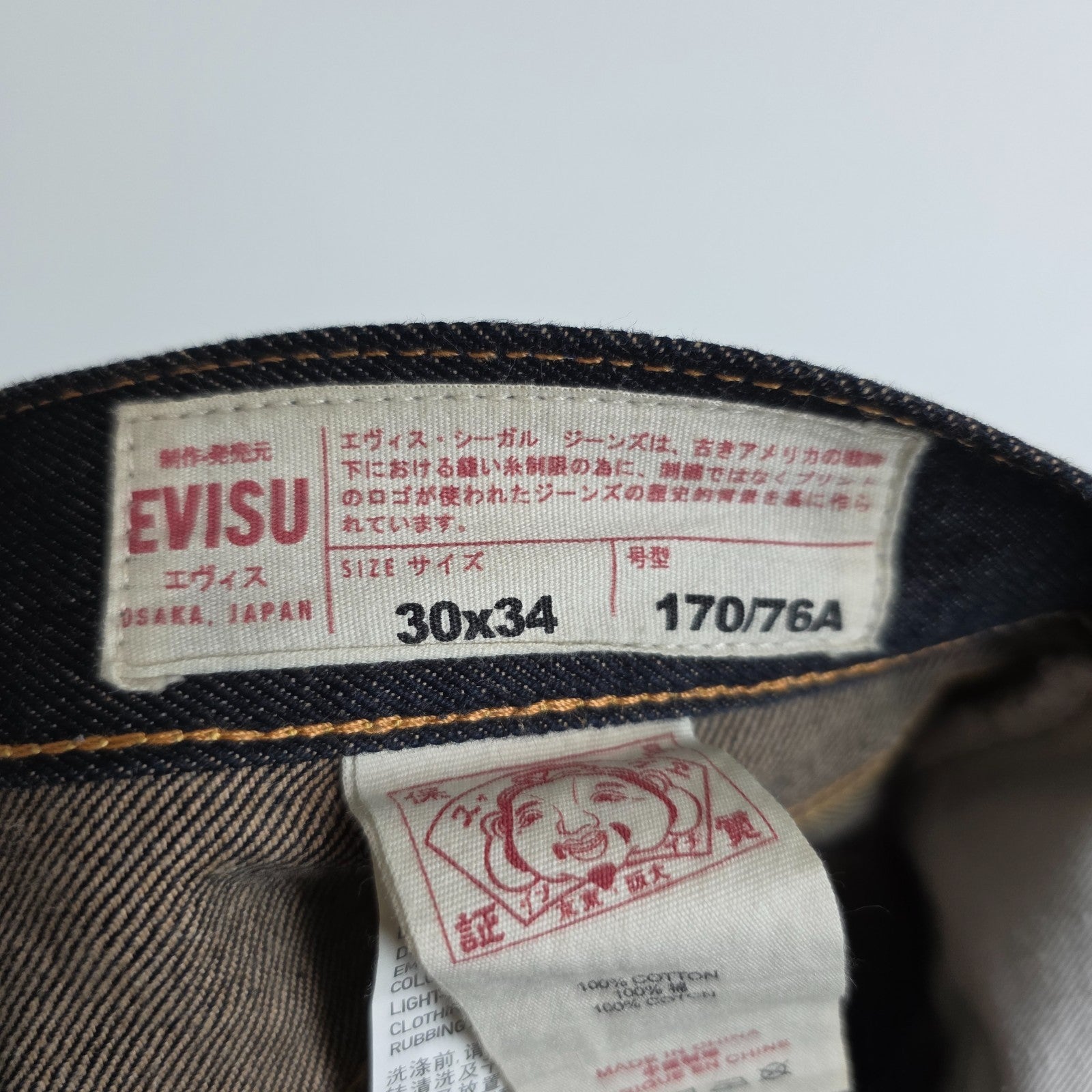 Evisu blue straight jeans with selvedge denim and button fly detailing.