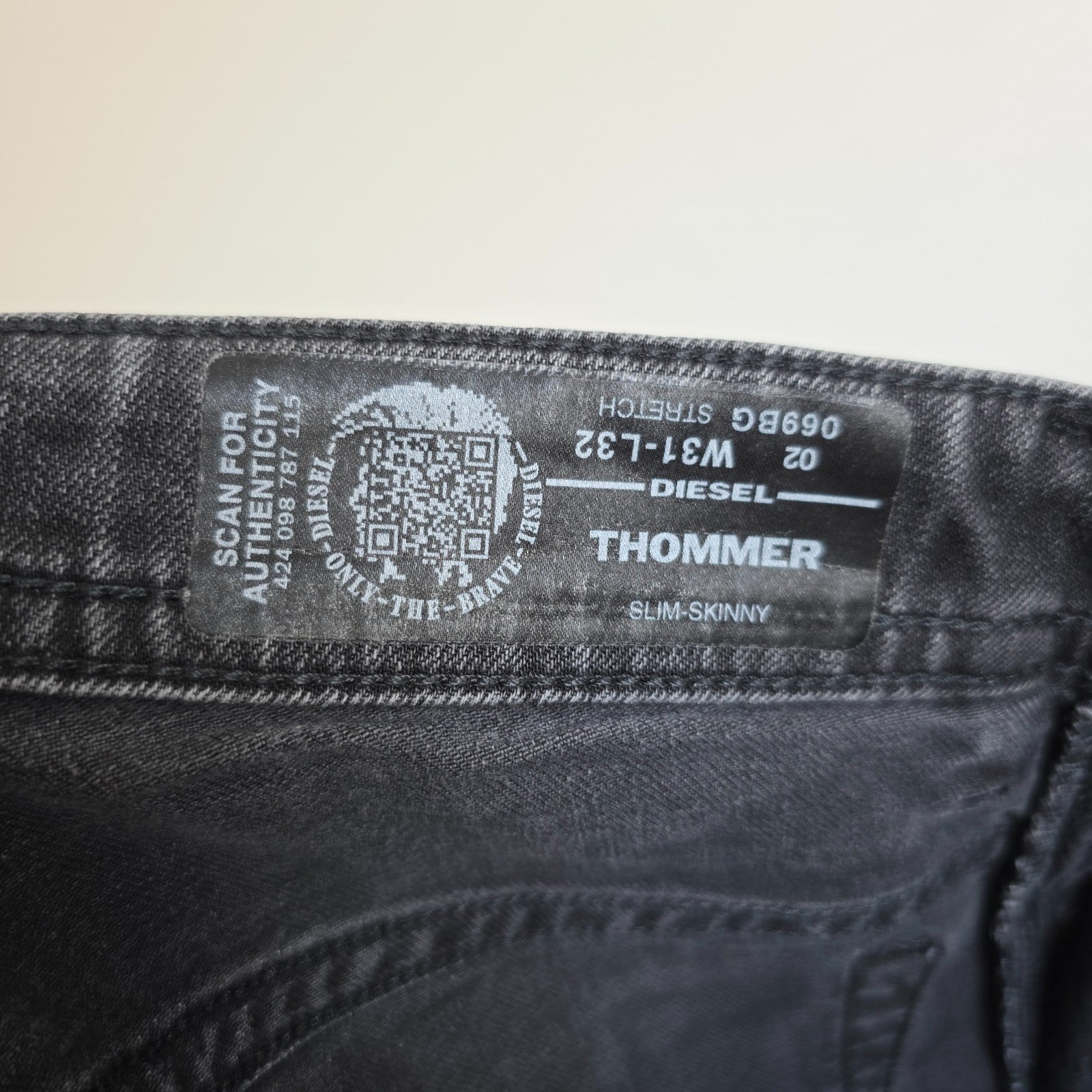 Diesel black straight jeans with grey wash, stretch denim, and branded tag.