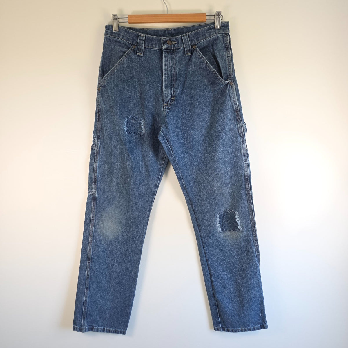 Wrangler blue carpenter jeans with distressed detailing, utility pockets, and hammer loop.