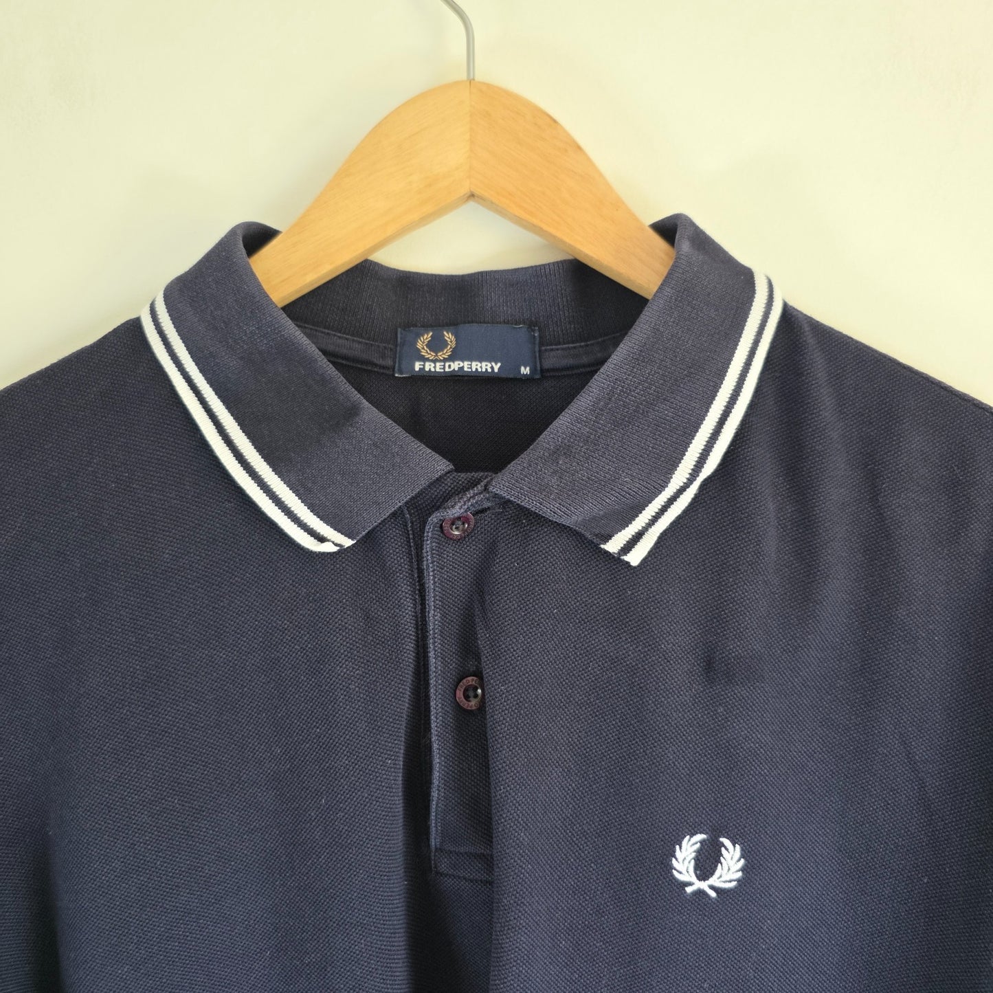 Fred Perry navy blue polo shirt with twin tipped collar and cotton material.