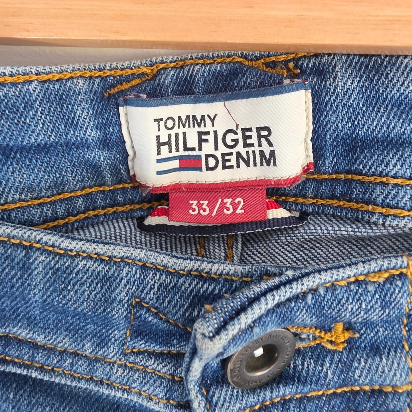 Tommy Hilfiger blue tapered jeans with stretch denim and small rip detail.
