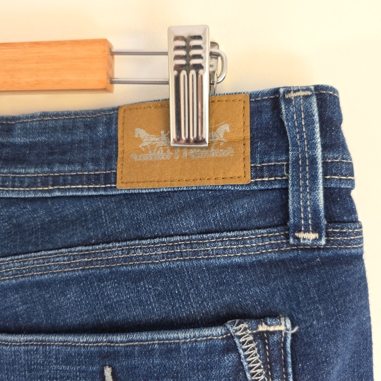 Levi's blue straight jeans with distressed details and classic 501 logo.