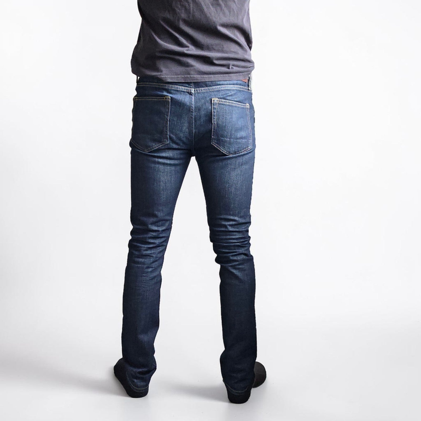 AllSaints blue skinny jeans with button fly and subtle logo detail.