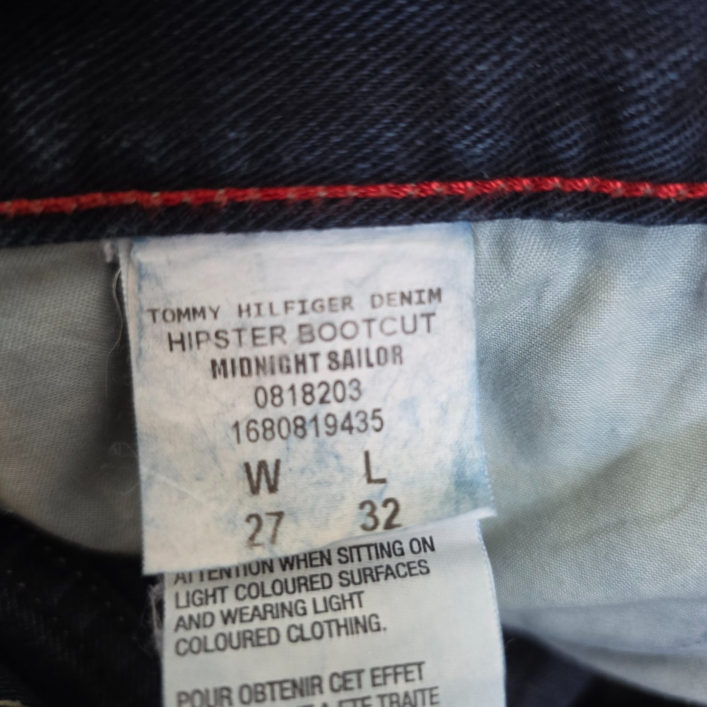 Tommy Hilfiger blue bootcut jeans with logo patch and classic denim texture.