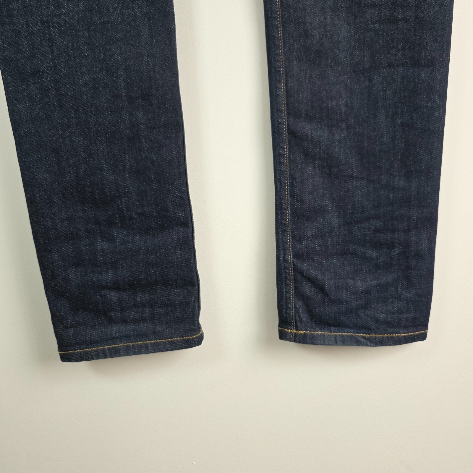 AllSaints blue skinny jeans with button fly and subtle logo detail.