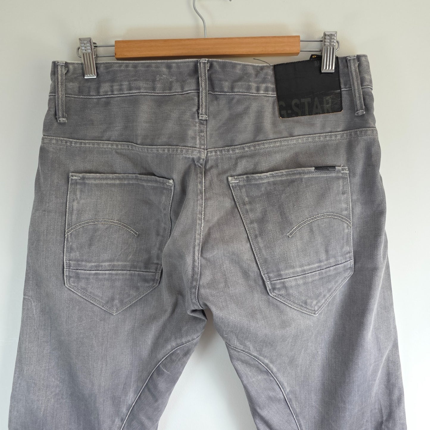 G-Star grey straight jeans with biker style detailing and subtle wear at the hem.