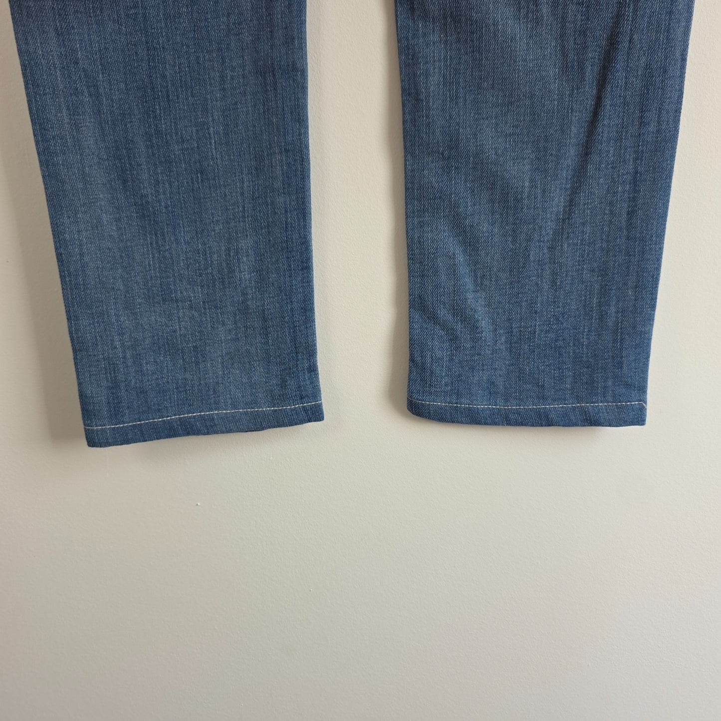 7 For All Mankind blue straight jeans with low rise and subtle branding details.