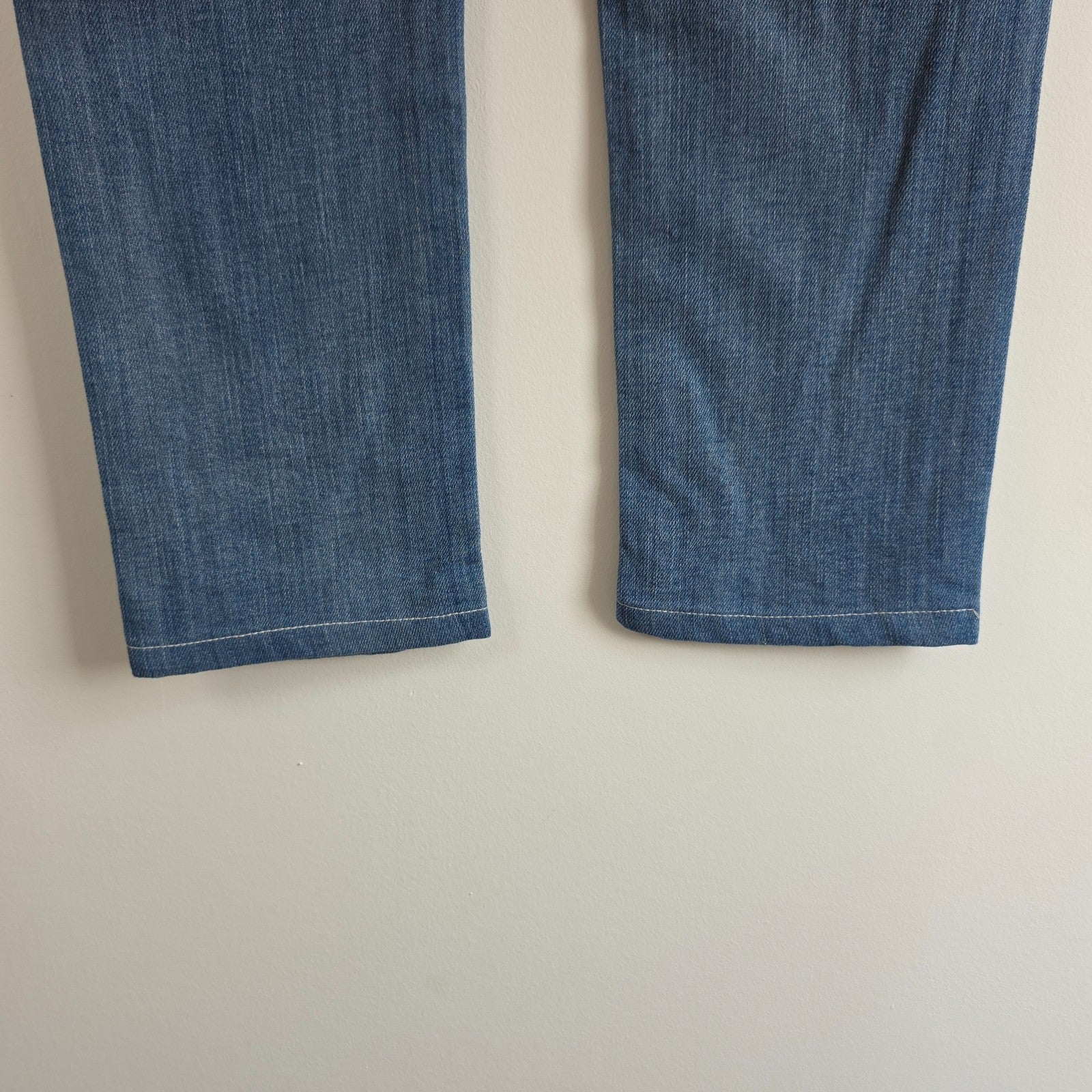 7 For All Mankind blue straight jeans with low rise and subtle branding details.