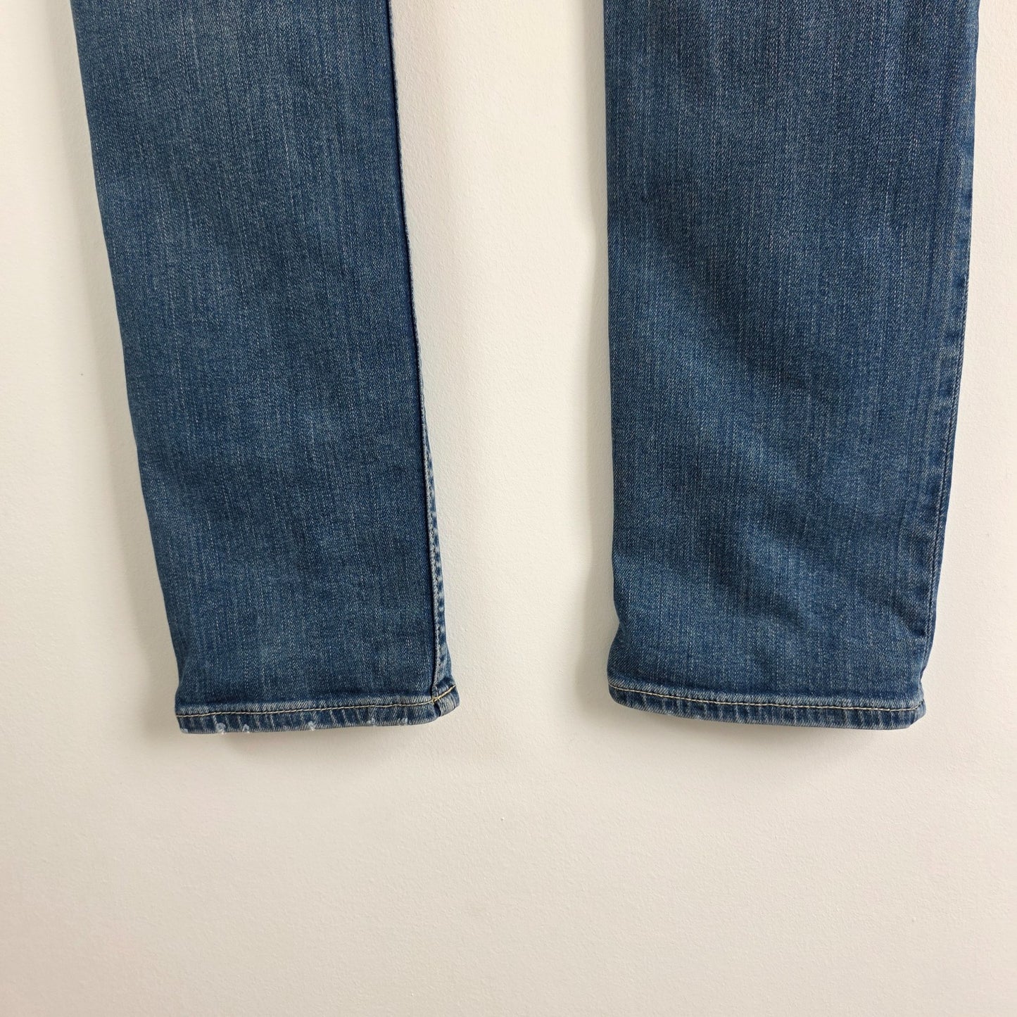AllSaints blue skinny jeans with faded wash and modern slim fit design.