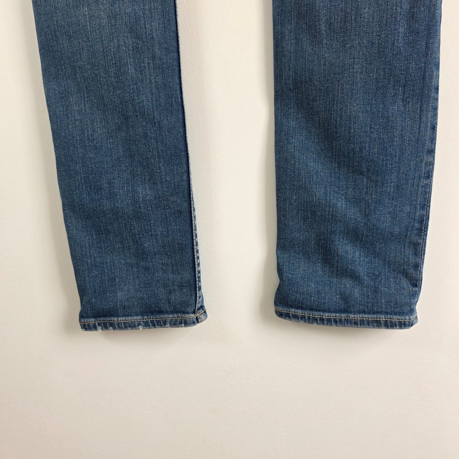 AllSaints blue skinny jeans with faded wash and modern slim fit design.