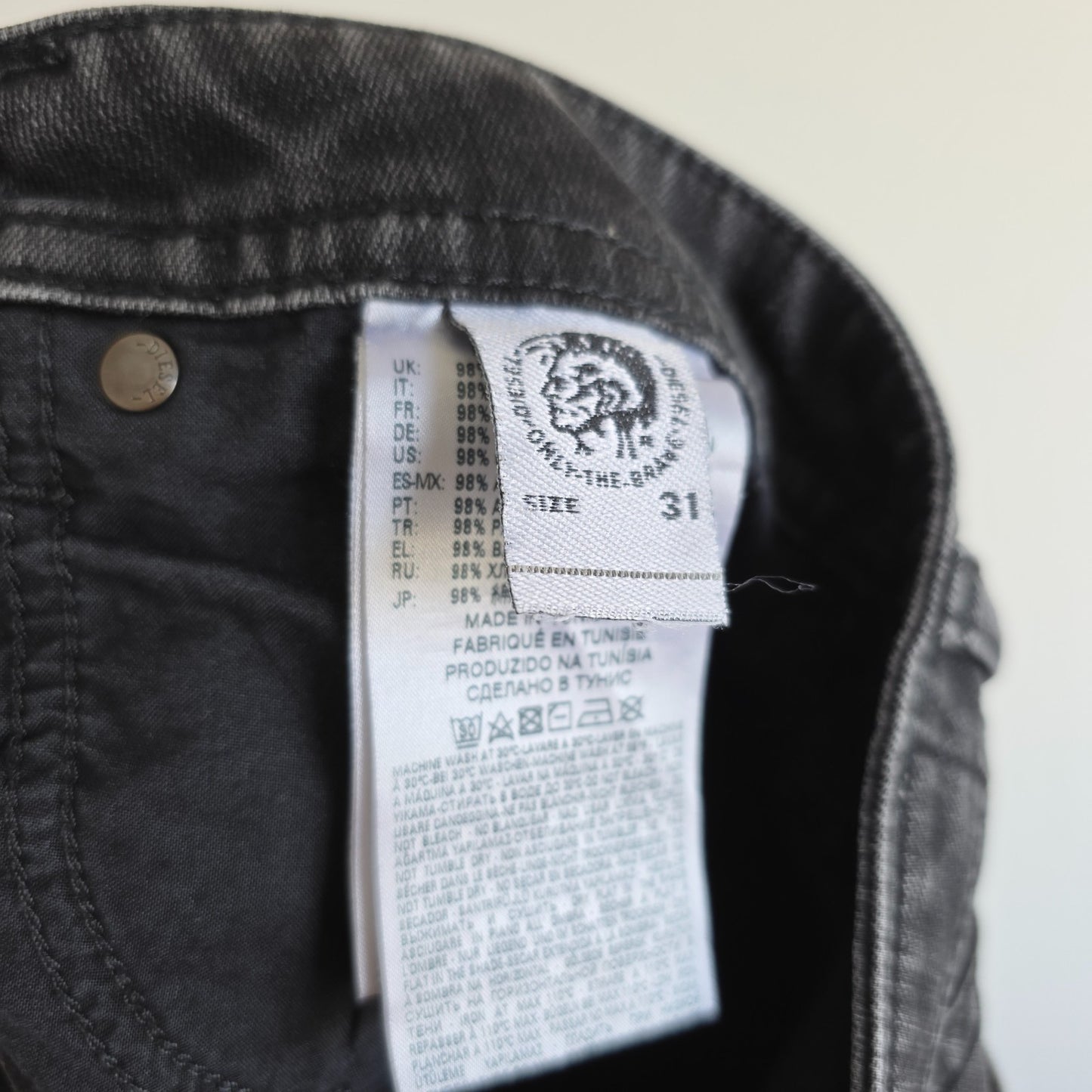 Diesel black straight jeans with grey wash, stretch denim, and branded tag.
