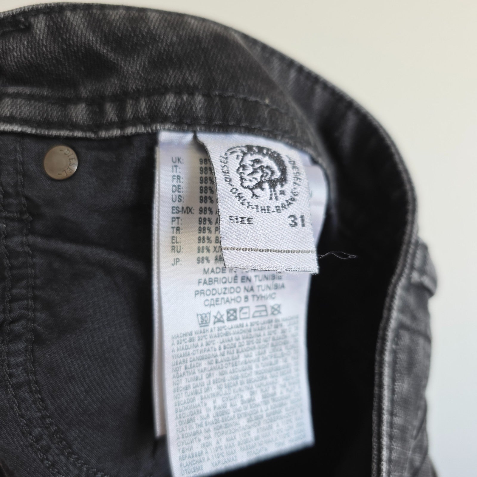 Diesel black straight jeans with grey wash, stretch denim, and branded tag.